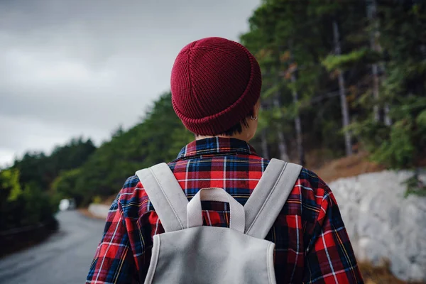 A woman hiker with a backpack enjoying a view of the mountains in the fog. Traveling in the mountains, freedom and an active lifestyle