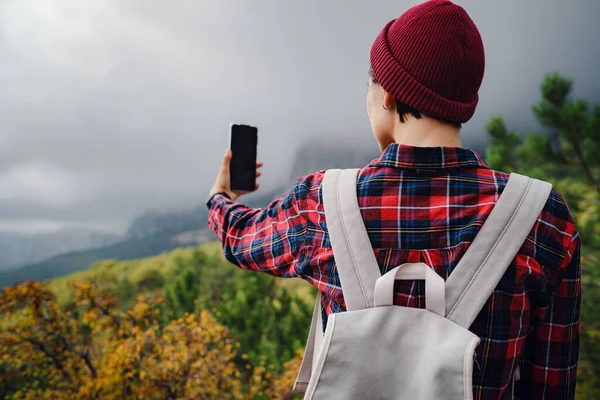 Woman tourist taking photo by smartphone on mountain traveling, adventure lifestyle active vacations modern technology connection concept