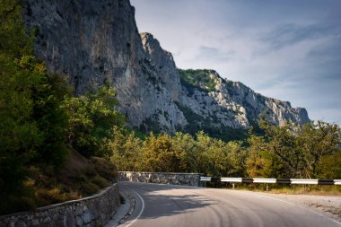Dağlarda asfalt yol, güzel güneş ışığı, yaz tatili. Klasik tonlama. Seyahat geçmişi. Avrupa dağlarında otoyol