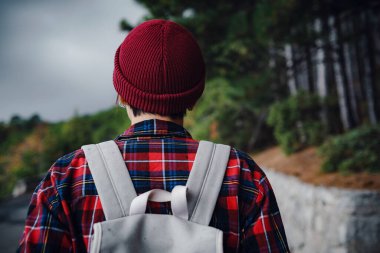 Sırt çantalı bir kadın yürüyüşçü siste dağları seyrediyor. Dağlarda seyahat, özgürlük ve aktif bir yaşam tarzı.