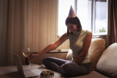 Karantina zamanında doğum gününü kutlayan bir bayan. Doğum gününü arkadaşlarıyla sanal parti aracılığıyla kutlayan bir kadın. Otantik dekore edilmiş ev işyeri. Coronavirüs salgını 2020.