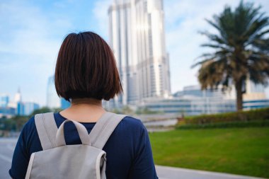 Genç ve güzel bir kadın Dubai şehir merkezinin manzarasının keyfini çıkarıyor. Birleşik Arap Emirlikleri 'nde keyifli yolculuklar..