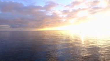 Denizde kızıl gün batımı. Güneş ufukta beliriyor. Kızıl gökyüzü, sarı güneş ve inanılmaz deniz. Yaz günbatımı deniz manzarası. Atlantik Okyanusu plaj günbatımı. Güneş dönen bulutlarda. İnanılmaz doğal gün batımları.