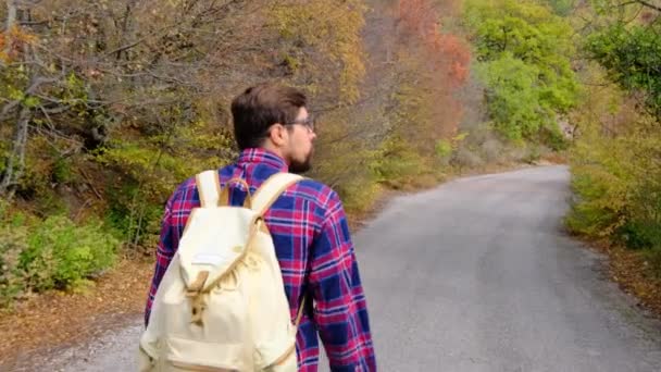 Traveler Guy caminha no pitoresco lugar da vida selvagem e olha para a paisagem do outono — Vídeo de Stock