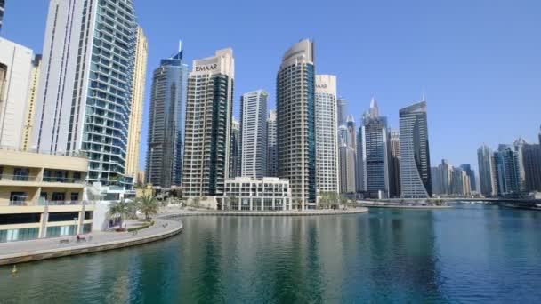 ドバイ アラブ首長国連邦 2021 マリーナ運河とドバイマリーナスカイライン 近代的な高層ビル 豪華なホテルやヨットがドックに係留され Gharbi Streetから見た湾の波に揺れています — ストック動画