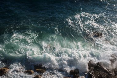 Okyanus dalgası arka planı deniz suyunu kırıyor kayalık kıyı dalgalı deniz turkuaz su gradyan köpüğü. Açık denizde büyük dalgalar. Yaz musonu. Bir deniz dalgasının beyaz tepesi.