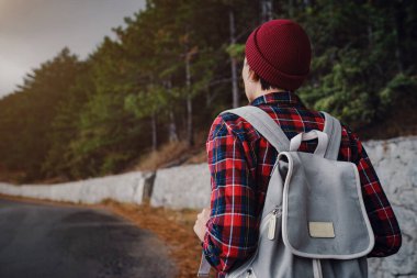 Sırt çantalı bir kadın yürüyüşçü siste dağları seyrediyor. Dağlarda seyahat, özgürlük ve aktif bir yaşam tarzı.