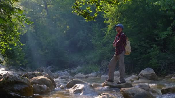 Mężczyzna Podróżnik Cieszący Się Pięknem Natury Nad Rzeką Lesie Zachodzie — Wideo stockowe