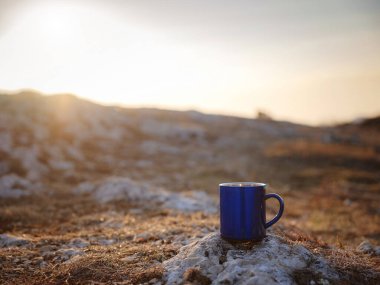 Odak dağları manzarası dışında çaylı fincanın yakın çekimi. Trek konsepti