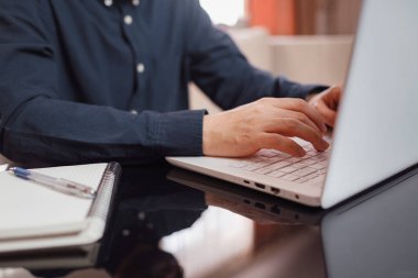 Evde dizüstü bilgisayar kullanan iş adamı veya öğrenci, bilgisayarın klavyesine el yazısıyla yazı yazması, çevrimiçi öğrenme, internet pazarlaması, evden, işyerinden serbest çalışma