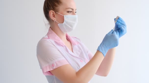 Vrouwelijke Arts Roze Uniform Beschermend Masker Vullen Spuit Met Medicatie — Stockvideo