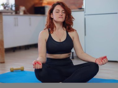 Çevrimiçi Eğitim. Evde antrenman yapan, akıllı telefondan video dersi izleyen sağlıklı genç bir kadın. Kişisel izolasyon internetteki yararlı, eğlenceli ve eğitimli bir şey. Sağlıklı yaşam tarzı kavramı.