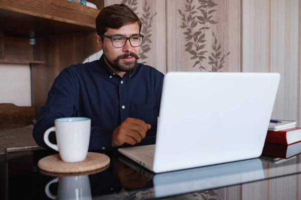 Focused man sitting at desk watching webinar video course gain new knowledge use on-line application website. Manager talk to client provide professional help and support concept