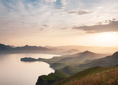 Deniz kıyıları ve dağların gün batımında büyüleyici bir manzara. Karadeniz kıyısı, Koktebel manzarası, büyük Karadağ