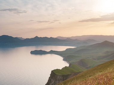 Deniz kıyıları ve dağların gün batımında büyüleyici bir manzara. Karadeniz kıyısı, Koktebel manzarası, büyük Karadağ
