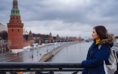 Moskova 'da kışın seyahat eden Asyalı turist. Moskova 'nın merkezindeki soğuk Kızıl Meydan' da poz veren kadın,