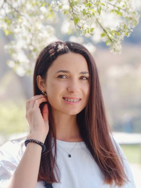 Açık havada gülümseyen esmer kadın portresi. Güneşli bahar ya da yaz günü doğada