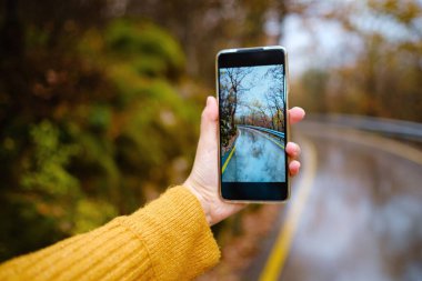 Fotoğraf çekmek için cep telefonu tutan bir kadın.