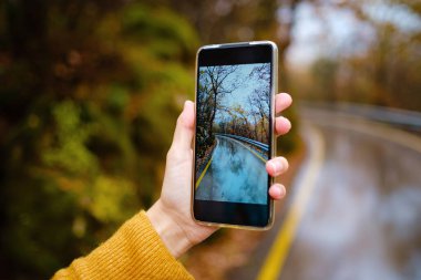 Fotoğraf çekmek için cep telefonu tutan bir kadın.