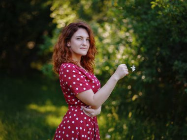 Güzel bir kadın yaz ormanının sessizliğinin tadını çıkarıyor.