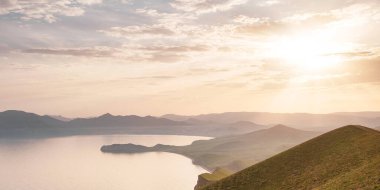Deniz kıyıları ve dağların gün batımındaki büyüleyici manzara.