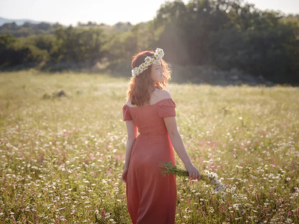 Red-haired woman on a field on a summer evening — Stock Photo, Image