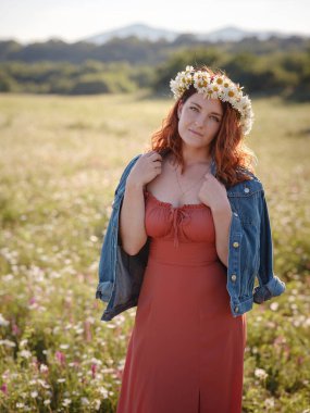 Kızıl saçlı kadın yaz akşamı sahada.