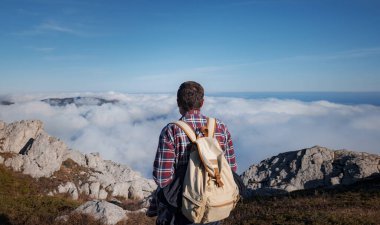 Genç adam bir dağda dijital kamerayla fotoğraf çekiyor..