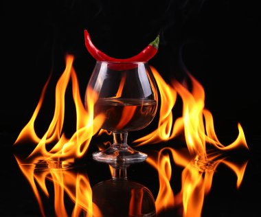 Bir konyak ballon siyah bir zemin üzerine bir ateşle sıcak biber biber