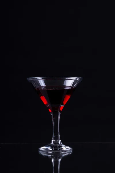 Vin rouge dans un verre de martini sur fond noir — Photo