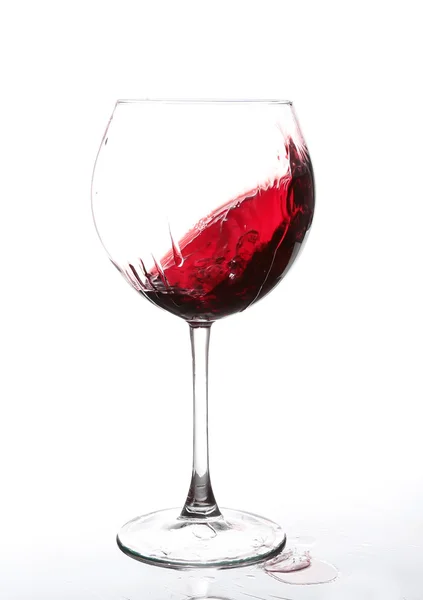 Rode wijn zwenken in een goblet wijn glas, geïsoleerd op een witte achtergrond — Stockfoto