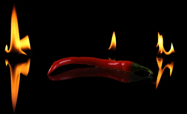 Pimienta picante con llama sobre fondo negro — Foto de Stock