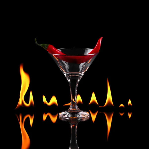 Pimienta picante en una copa de martini con un fuego en un respaldo negro —  Fotos de Stock