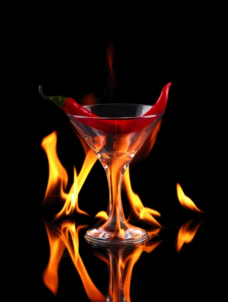 黒の背景に火とマティーニのグラスで唐辛子 — ストック写真