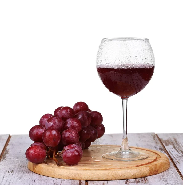 Вино наливая в бокал с виноградом и бутылки изолированы — стоковое фото