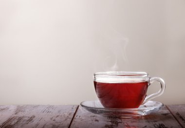 Cam bardak çay ve beyaz arka plan üzerinde bir cam daire üzerinde bir limon ile