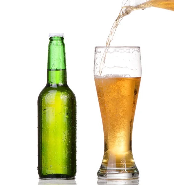 Наливание пива из бутылки на белом фоне — стоковое фото