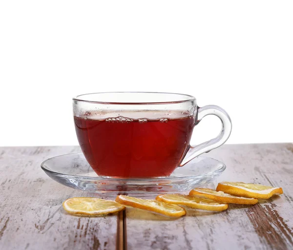 Coupe en verre avec thé et citron sur une soucoupe en verre isolée sur fond blanc — Photo