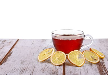 Cam bardak çay ve beyaz arka plan üzerinde izole bir cam daire üzerinde bir limon ile