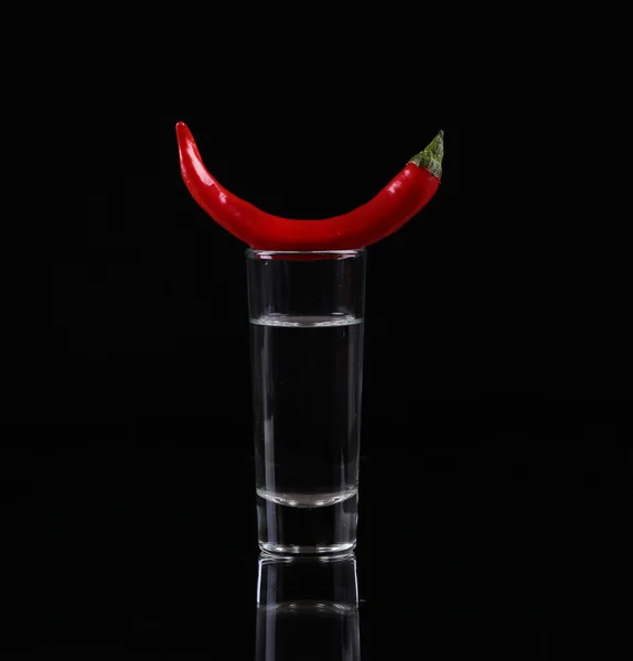 Hot chili pepper in a shot  glass with a fire on a black background — Stock Photo, Image