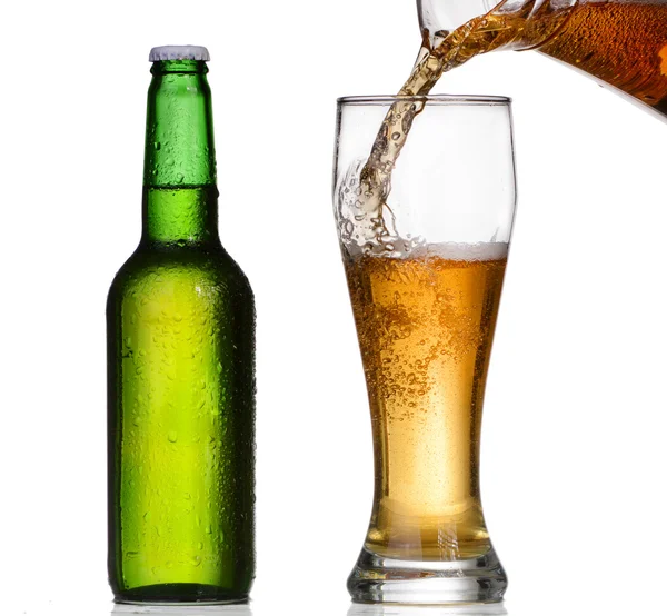 Beer pouring in a glass from a green bottle — Stock Photo, Image