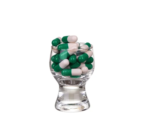 Ett glas tabletter och kapslar på vit bakgrund — Stockfoto