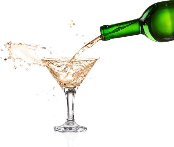 White wine pouring from the bottle intro the glass on white background — Stock Photo, Image