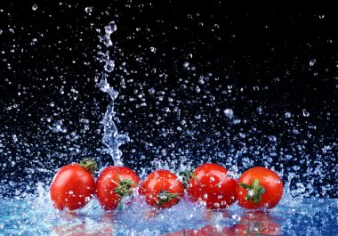 Studio shot with freeze motion of cherry tomatoes in water splas clipart