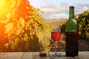 kırmızı şarap şişesi ve şarap kadehi yün fıçıda.