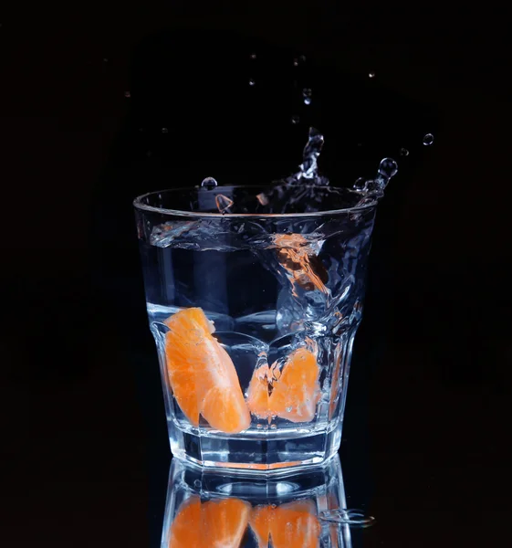 Schijfje citroen spatten in een glas water met een spray van w — Stockfoto