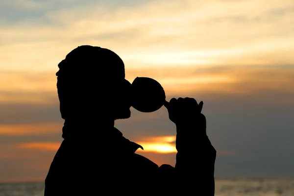 Silhouettes of man drinking a glass of champagne wine at sunset — Stock Photo, Image