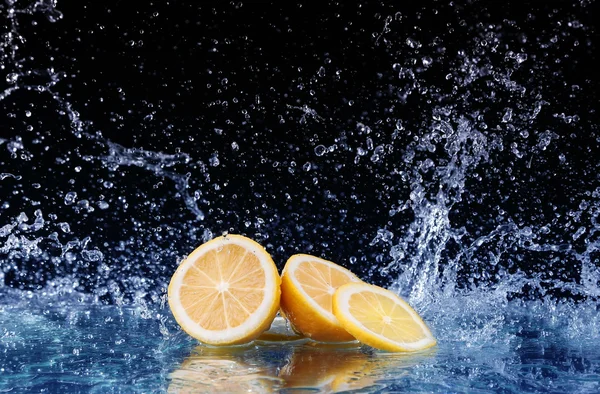 Plátky citronu ve vodě na černém pozadí — Stock fotografie