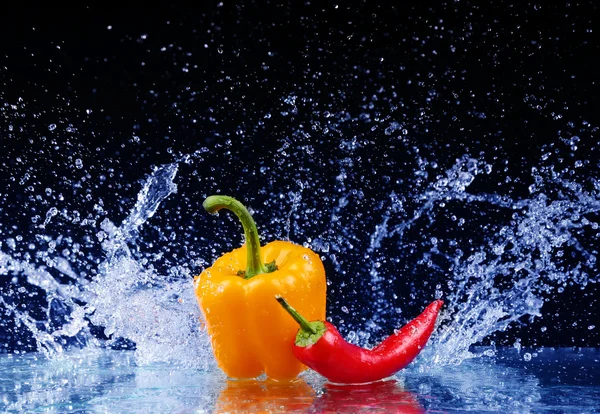 Pimenta em spray de água. Pimenta suculenta com respingo no fundo preto — Fotografia de Stock