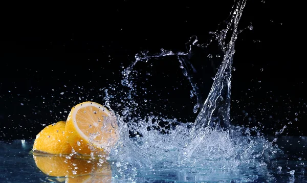 Gesneden citroen in het water op zwarte achtergrond — Stockfoto